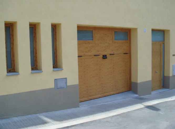 Porta de garatge seccional amb acabat fusta i finestres a joc