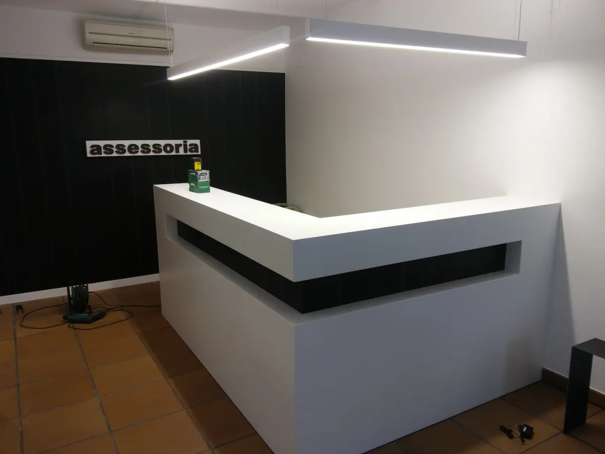 Taulell de recepció blanc amb llum LED en una assessoria